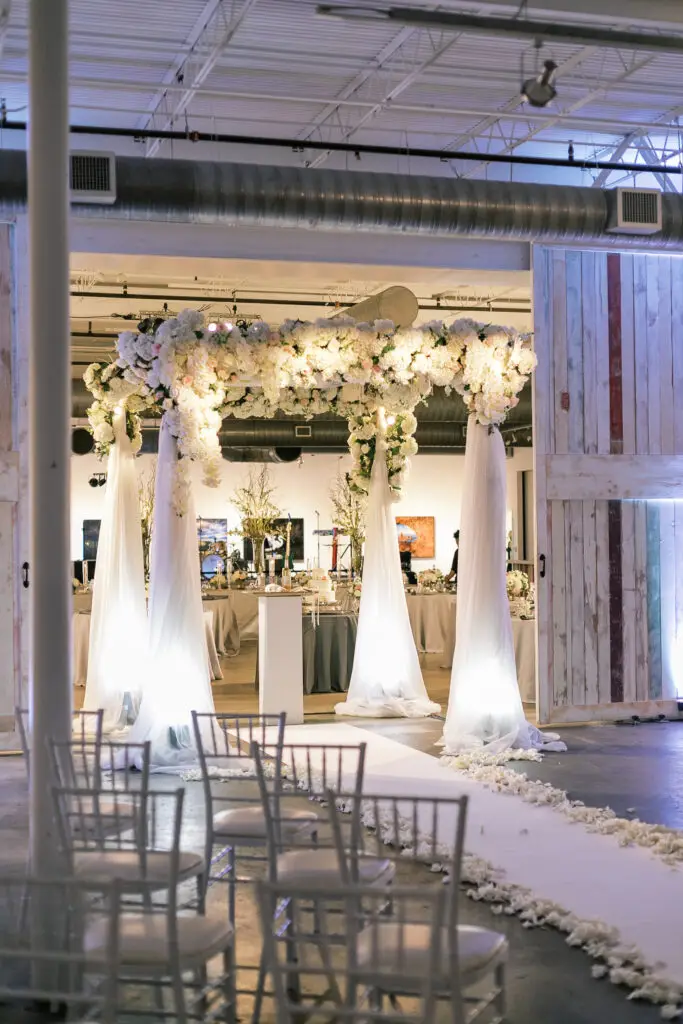 Outdoor wedding ceremony with a lush floral aisle